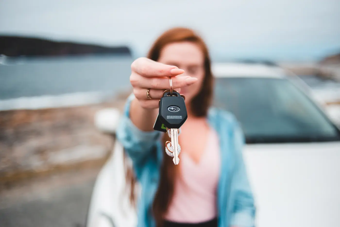 Driver holding vehicle keys outdoors