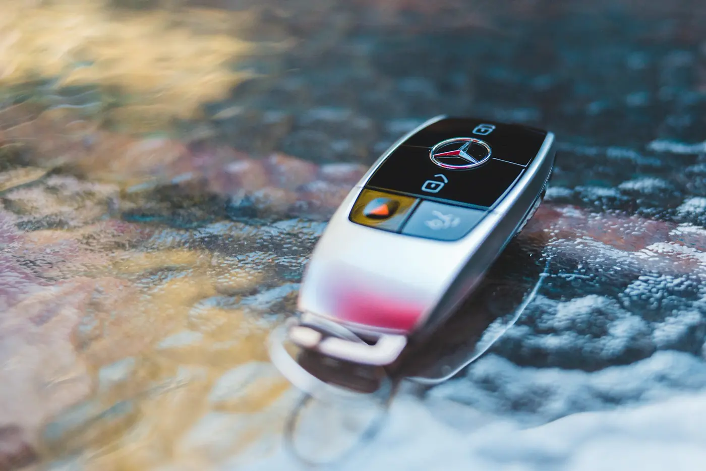 Metal vehicle key on a reflective surface