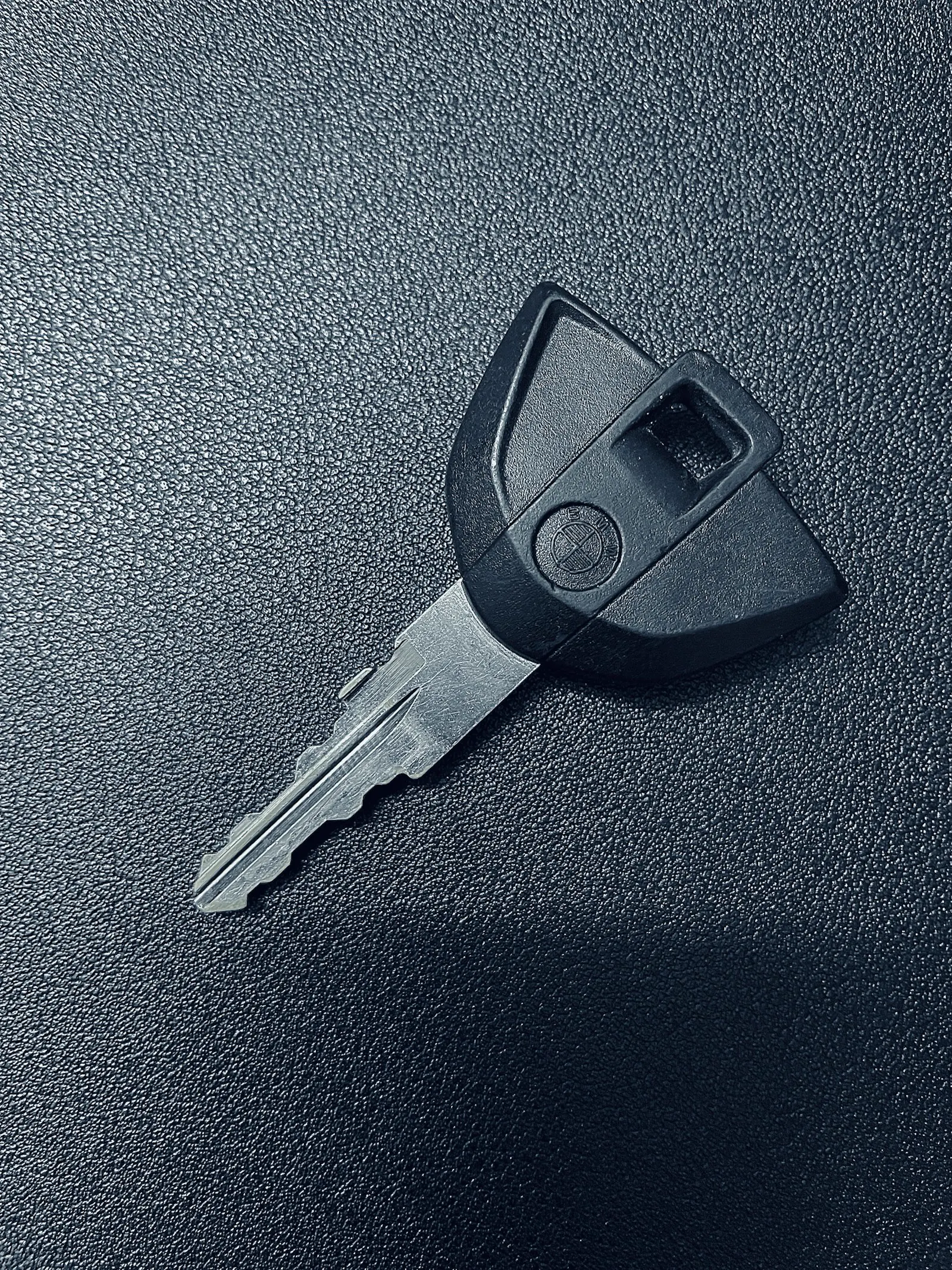Single vehicle key on a dark surface